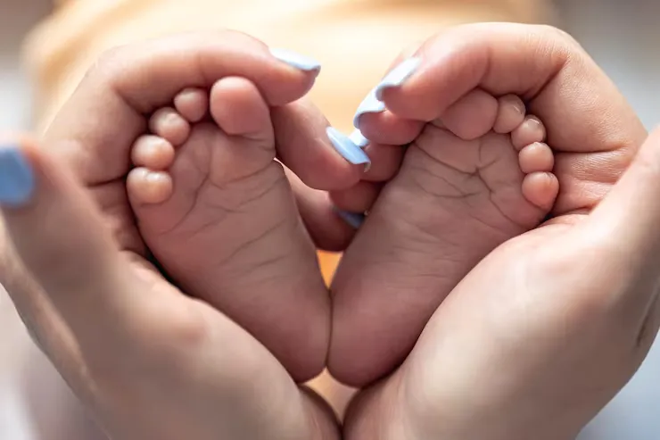 imgi_31_mom-holds-legs-newborn-baby-her-hands_169016-37057
